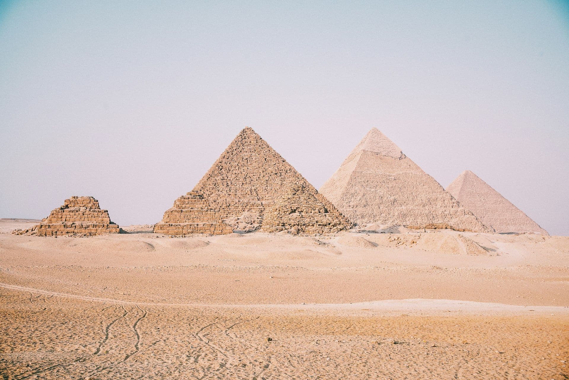 The three great pyramids of Giza and a smaller queen’s pyramid rising from the desert sand