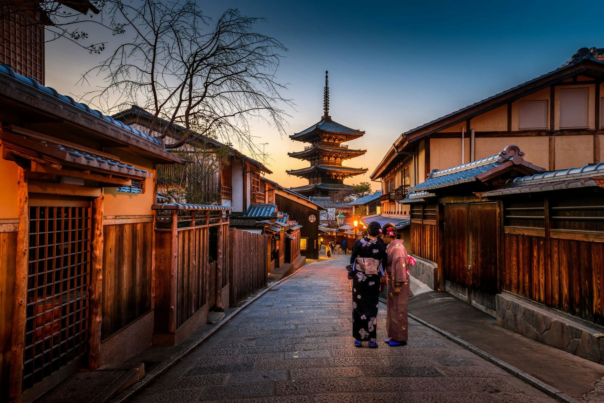 A pagoda at the end of a lantern-lit street in Kyoto at dusk