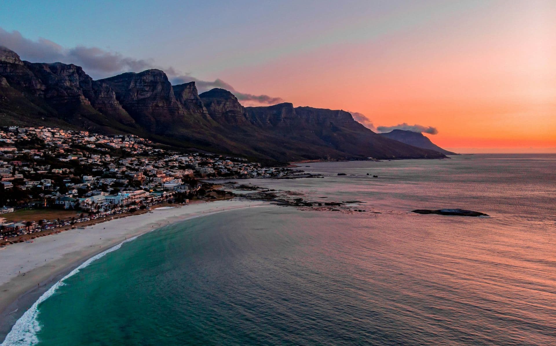 Camps Bay beach below the Twelve Apostles mountains at sunset