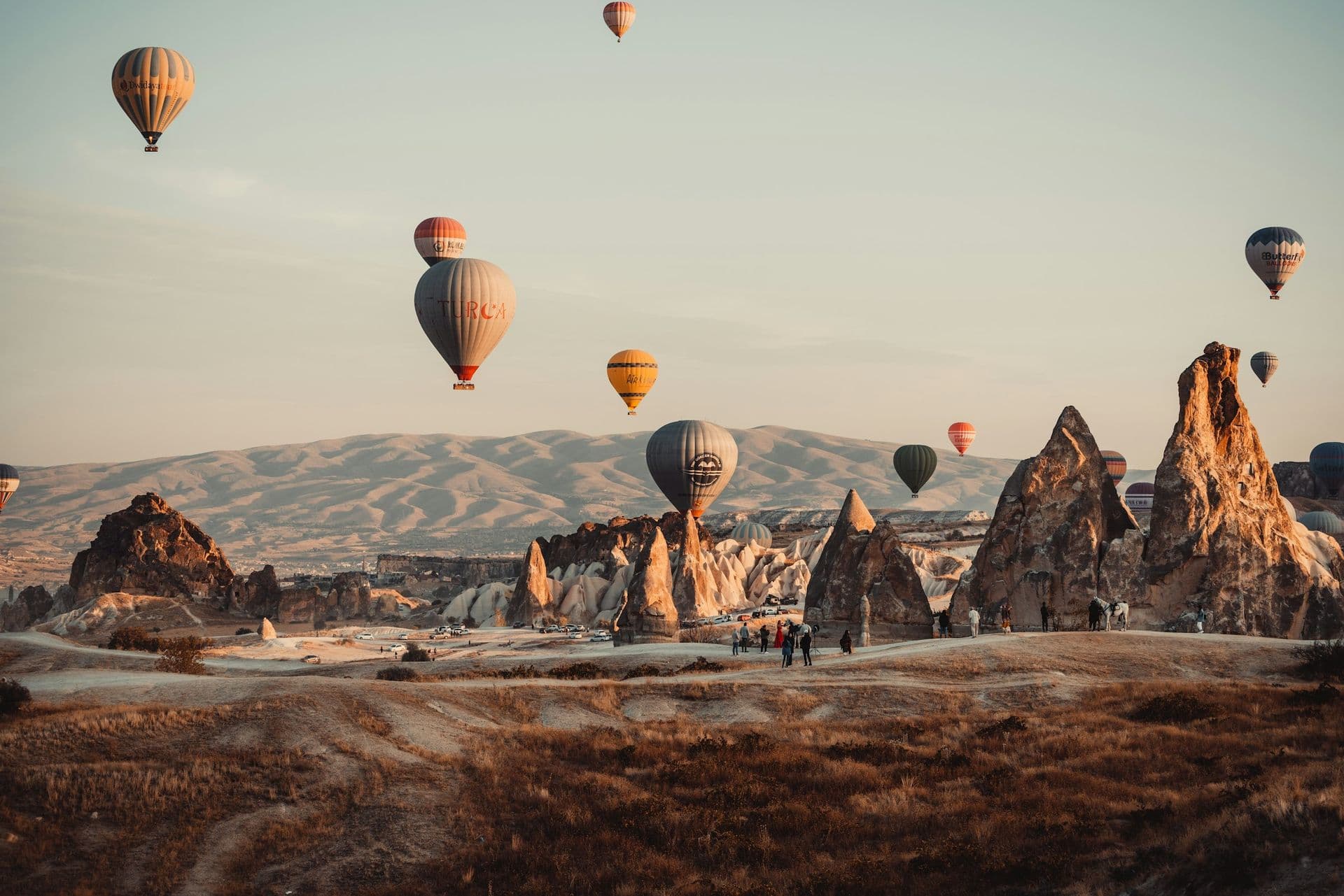 Hot air balloons drifting over the rock chimneys of Cappadocia at sunrise